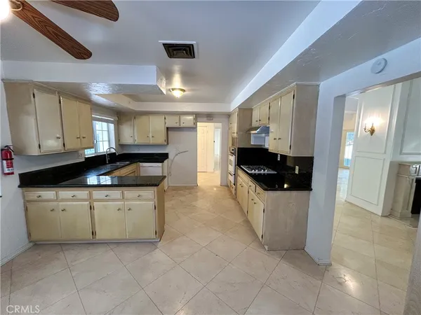 a kitchen with granite countertop a stove a sink and a refrigerator