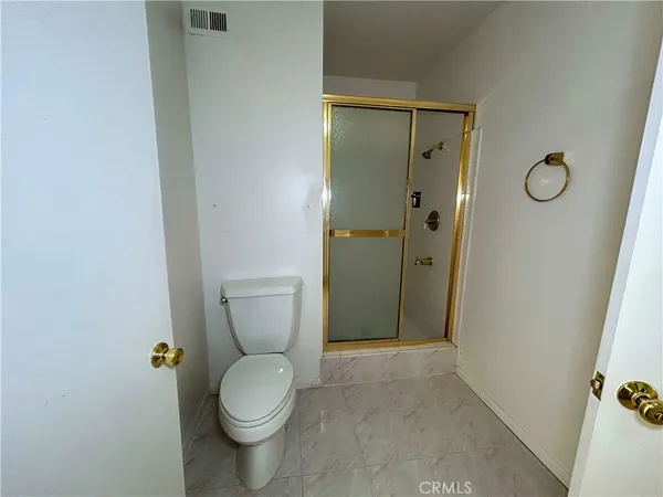 a bathroom with a granite countertop toilet a sink and shower