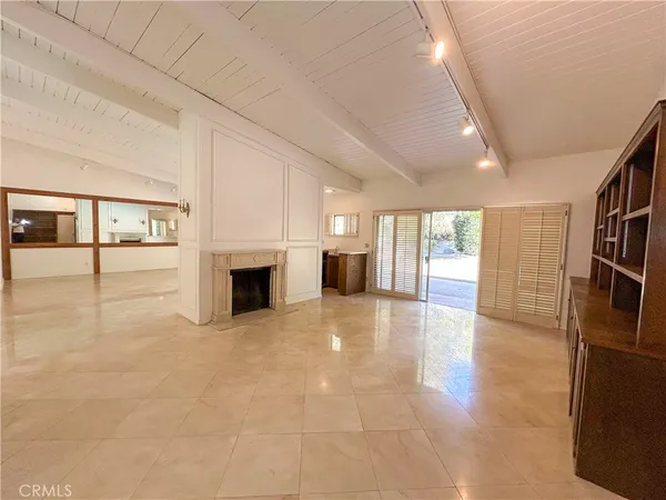 a view of an empty room with a fireplace and a window