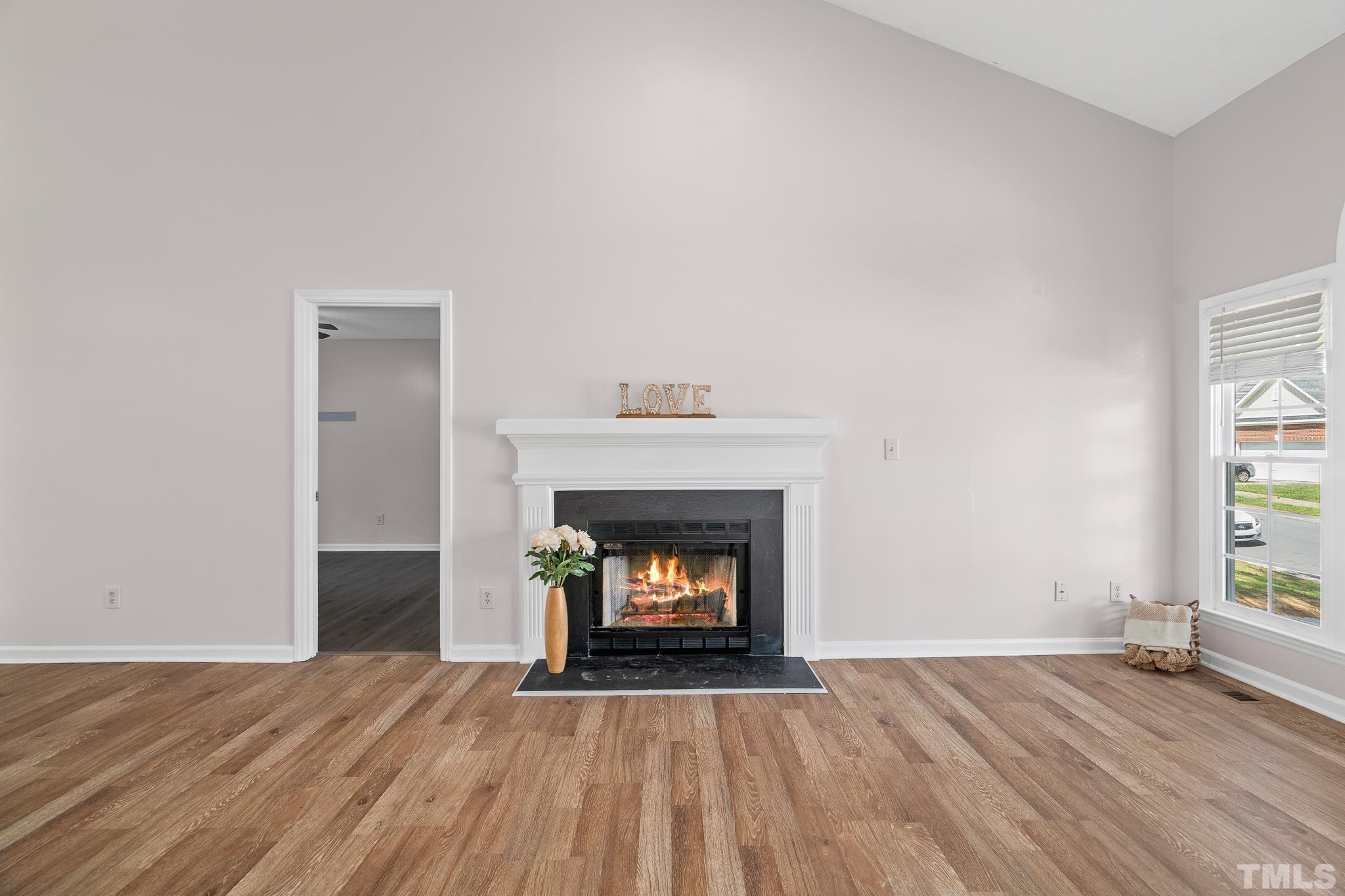 2201 Quail View Trail Raleigh, NC 27604 - Photo 4 of 28 a room with a fireplace wooden floor and window