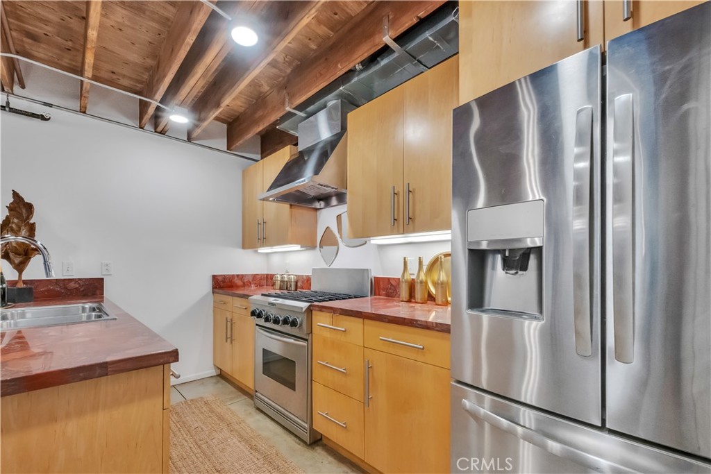 849 Pine Avenue, Unit C Long Beach, CA 90813 - Photo 20 of 63 a kitchen with stainless steel appliances granite countertop a refrigerator a stove and a sink with wooden floor