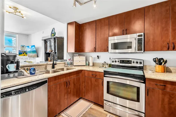 a kitchen with a sink a refrigerator and cabinets