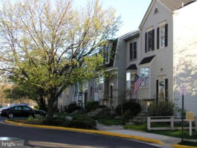 2390 Hunters Square Court Reston, VA 20191 - Photo 13 of 15 a front view of a house with a yard and trees