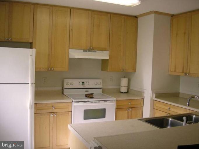 2390 Hunters Square Court Reston, VA 20191 - Photo 6 of 15 a kitchen with stainless steel appliances a stove a refrigerator and cabinets