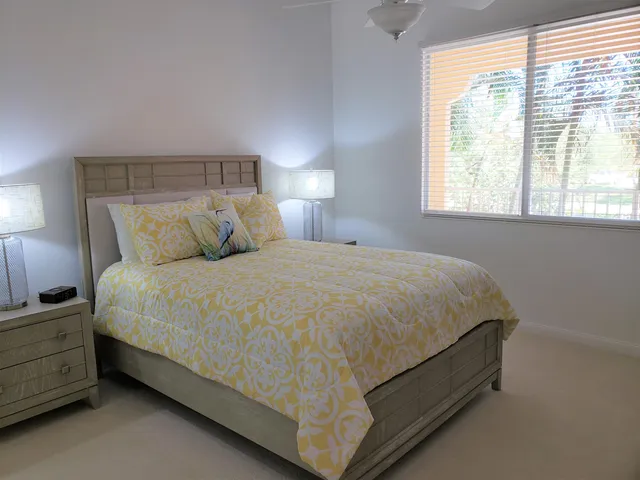 a bedroom with a bed a flat screen tv and a window