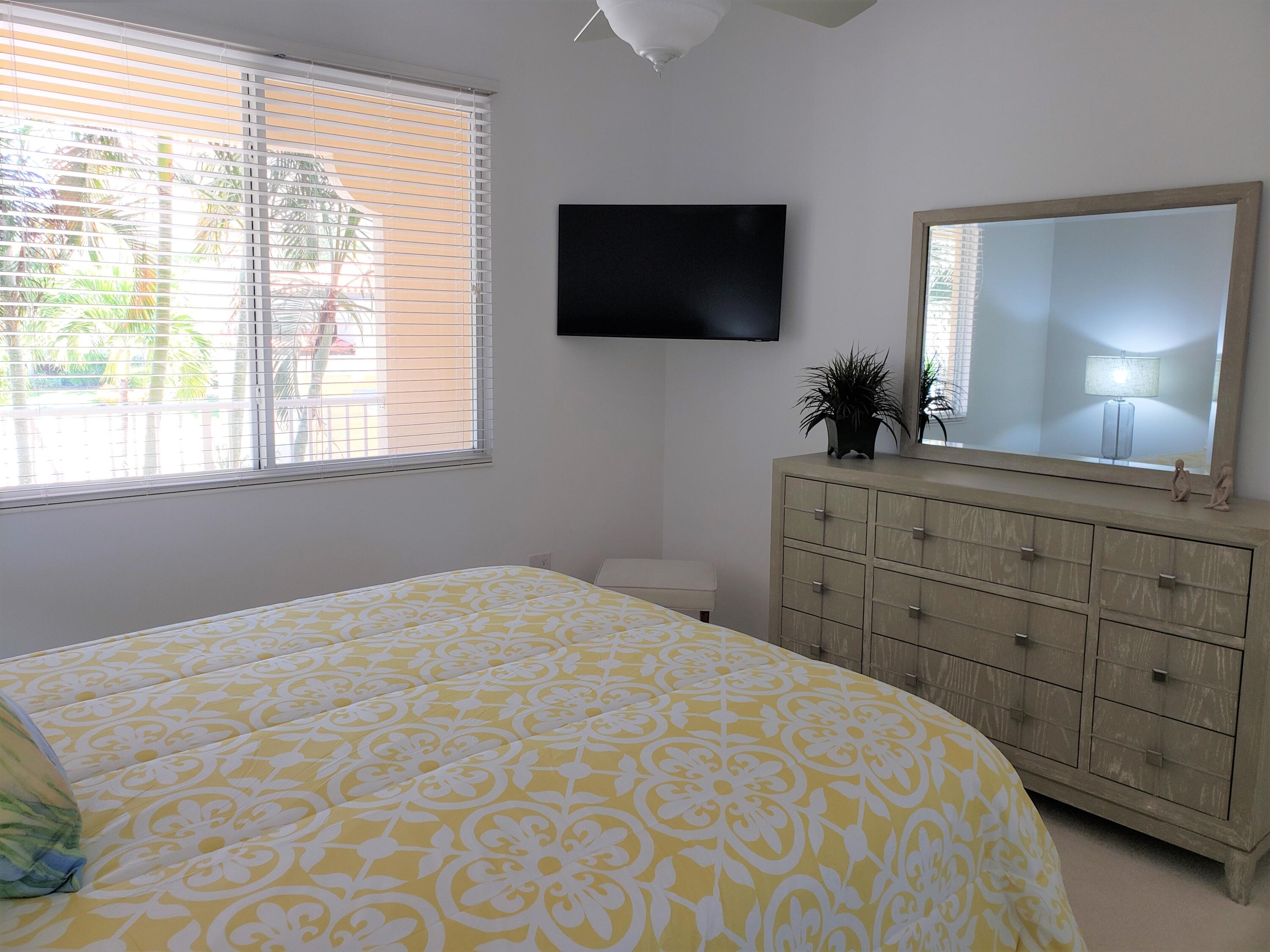 10 Harbour Isle Drive East, Unit 204 Fort Pierce, FL 34949 - Photo 18 of 20 a bedroom with a bed a flat screen tv and a window