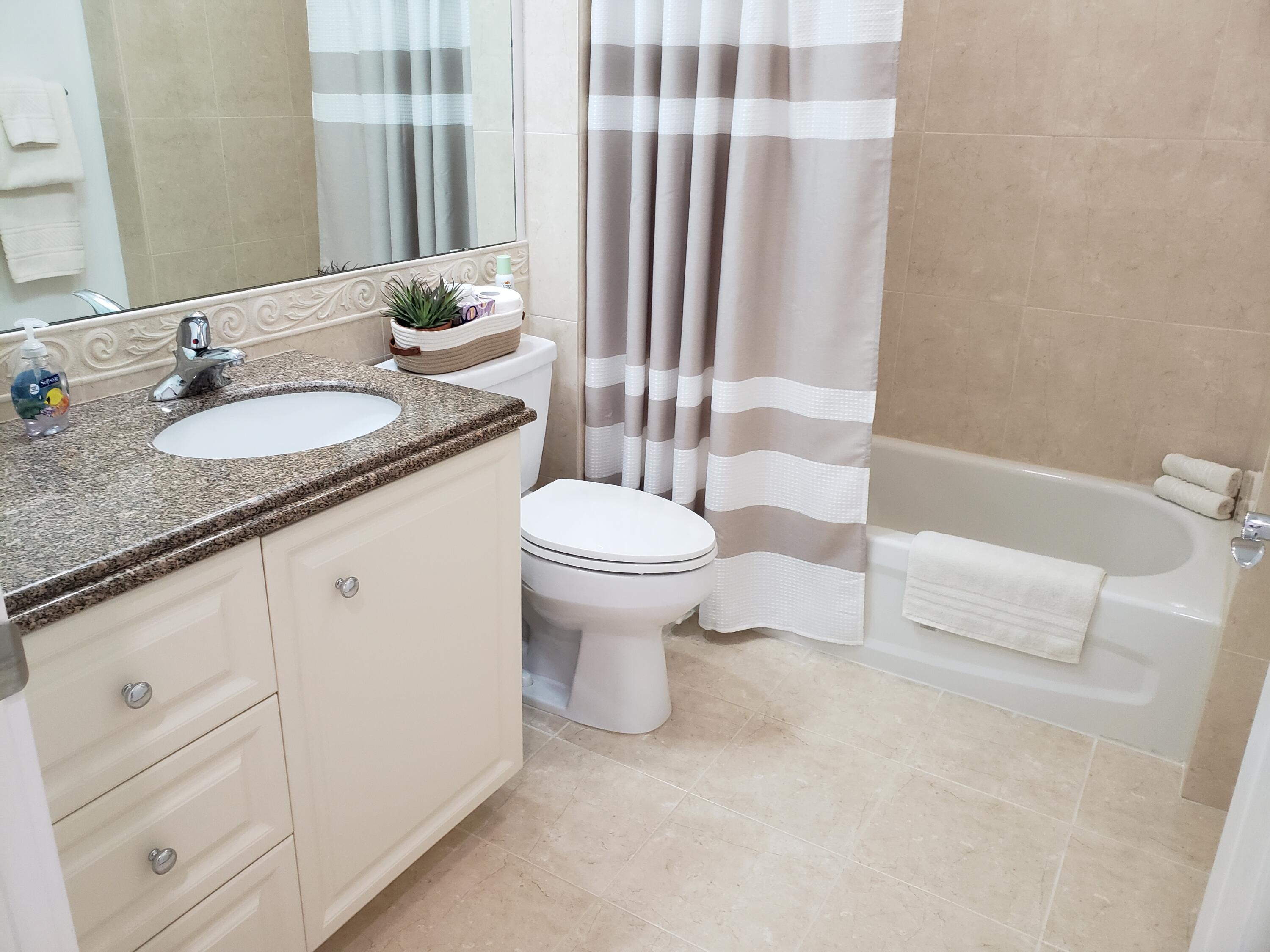 10 Harbour Isle Drive East, Unit 204 Fort Pierce, FL 34949 - Photo 19 of 20 a bathroom with a granite countertop sink toilet and shower
