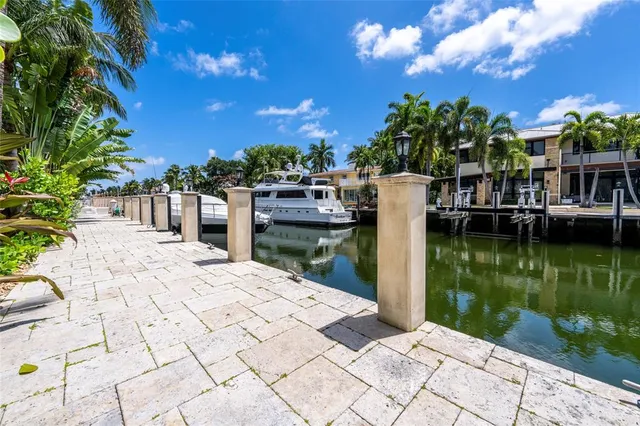 a view of a white house with large windows and a small yard