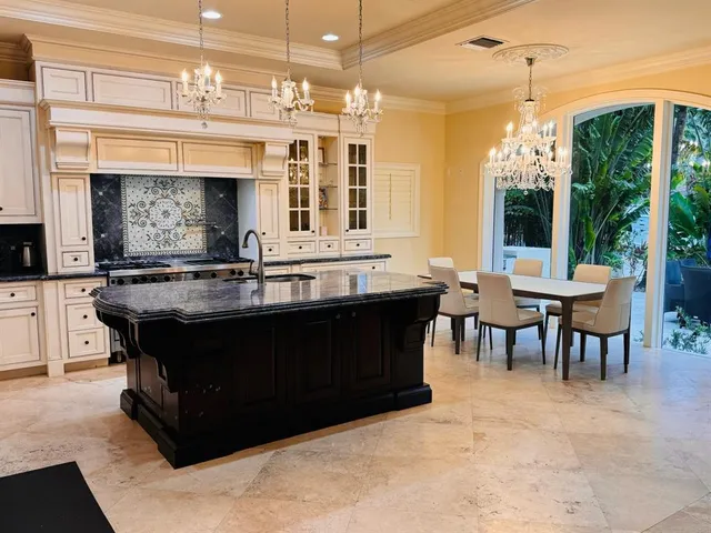 a living room with table chairs and a chandelier