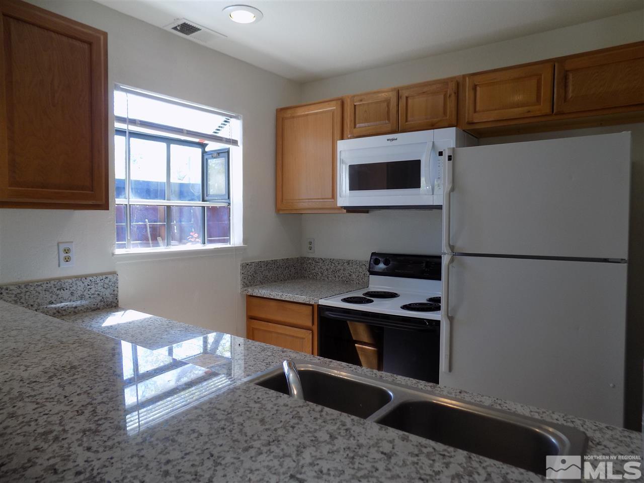 2189 Kietzke Lane Reno, NV 89502 - Photo 8 of 20 a kitchen with stainless steel appliances granite countertop a refrigerator a stove and a sink with wooden floor