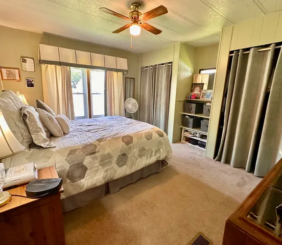 a bedroom with a bed closet and a large window