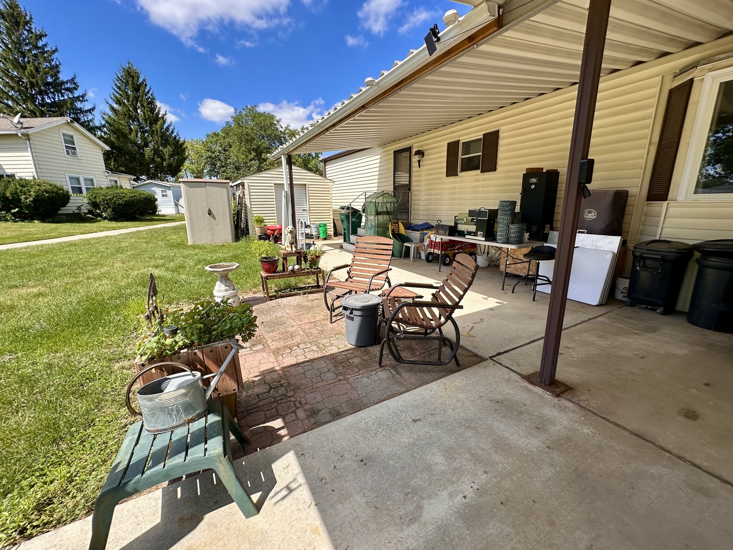1336 Douglas Avenue, Unit 13 Montgomery, IL 60538 - Photo 21 of 23 a view of a patio with table and chairs potted plants and a large tree