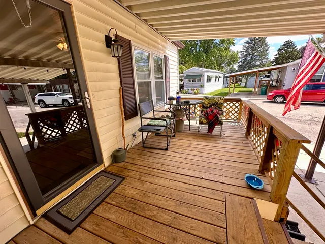 a view of a balcony with chairs and wooden floor