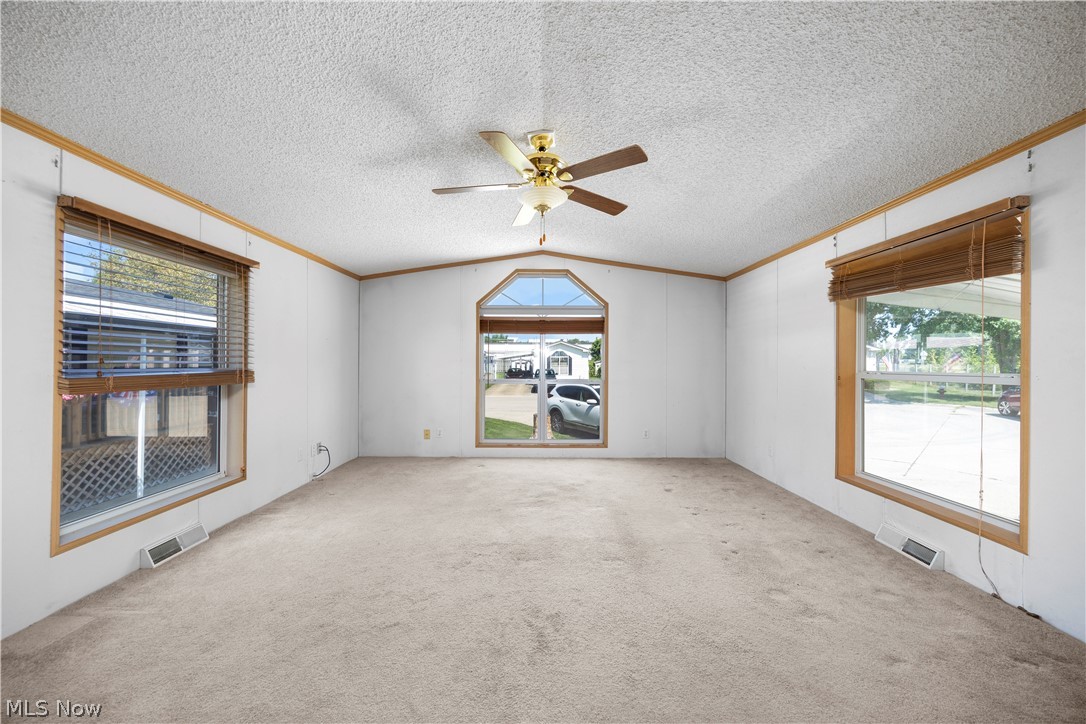 35157 Center Ridge Road, Unit 150 North Ridgeville, OH 44039 - Photo 21 of 33 Carpeted living space featuring a central arched window flanked by two large rectangular windows, all with wood-finish trim
