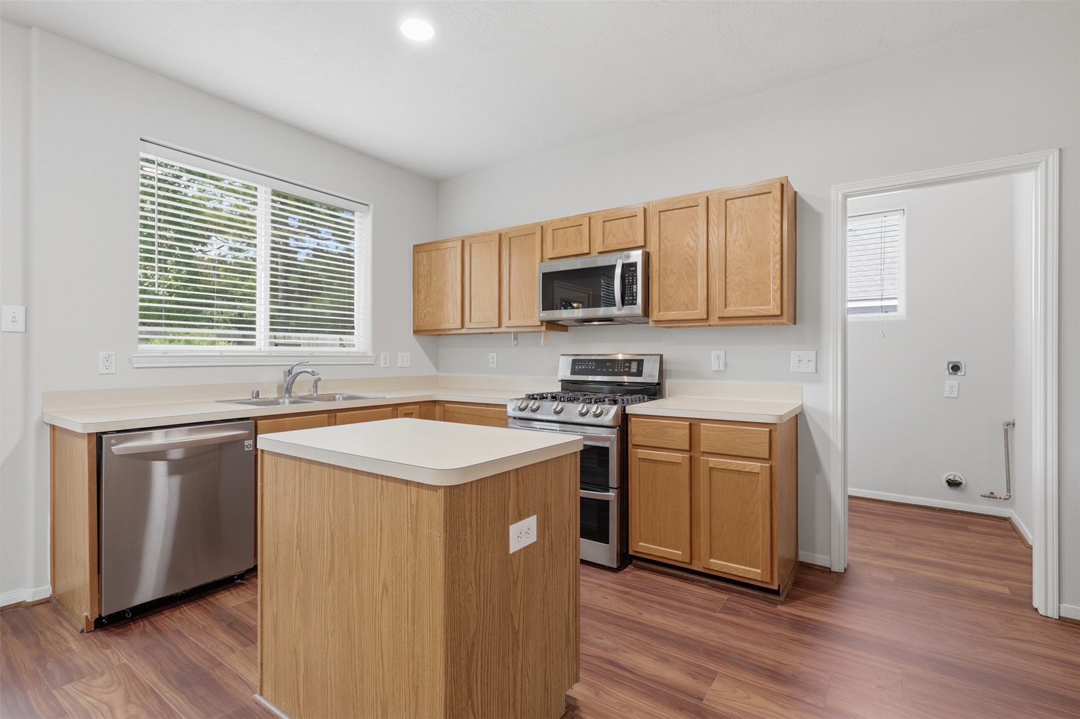 723 Slate Valley Lane Spring, TX 77373 - Photo 14 of 41 Spacious, well-appointed kitchen featuring abundant oak cabinetry, ample counter space, stainless steel appliances, a center island, double-basin sink, and warm wood-look flooring.