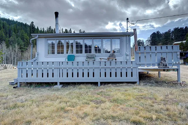 a view of a house with wooden fence and a yard
