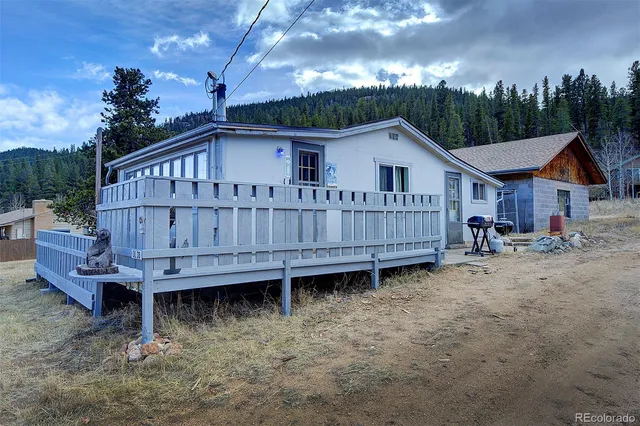 a view of a house with a yard and sitting area