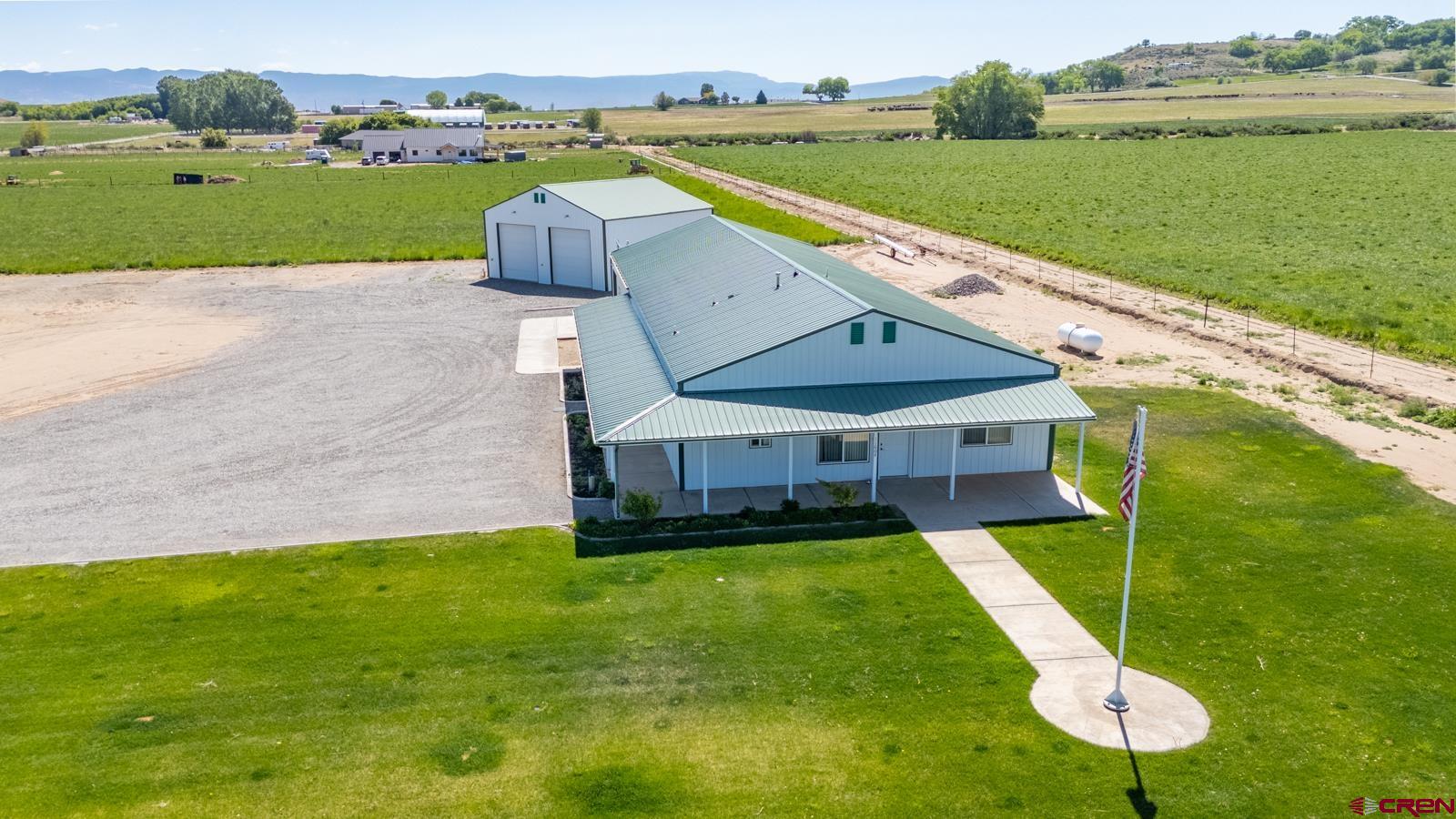 an aerial view of a house with a garden and lake view