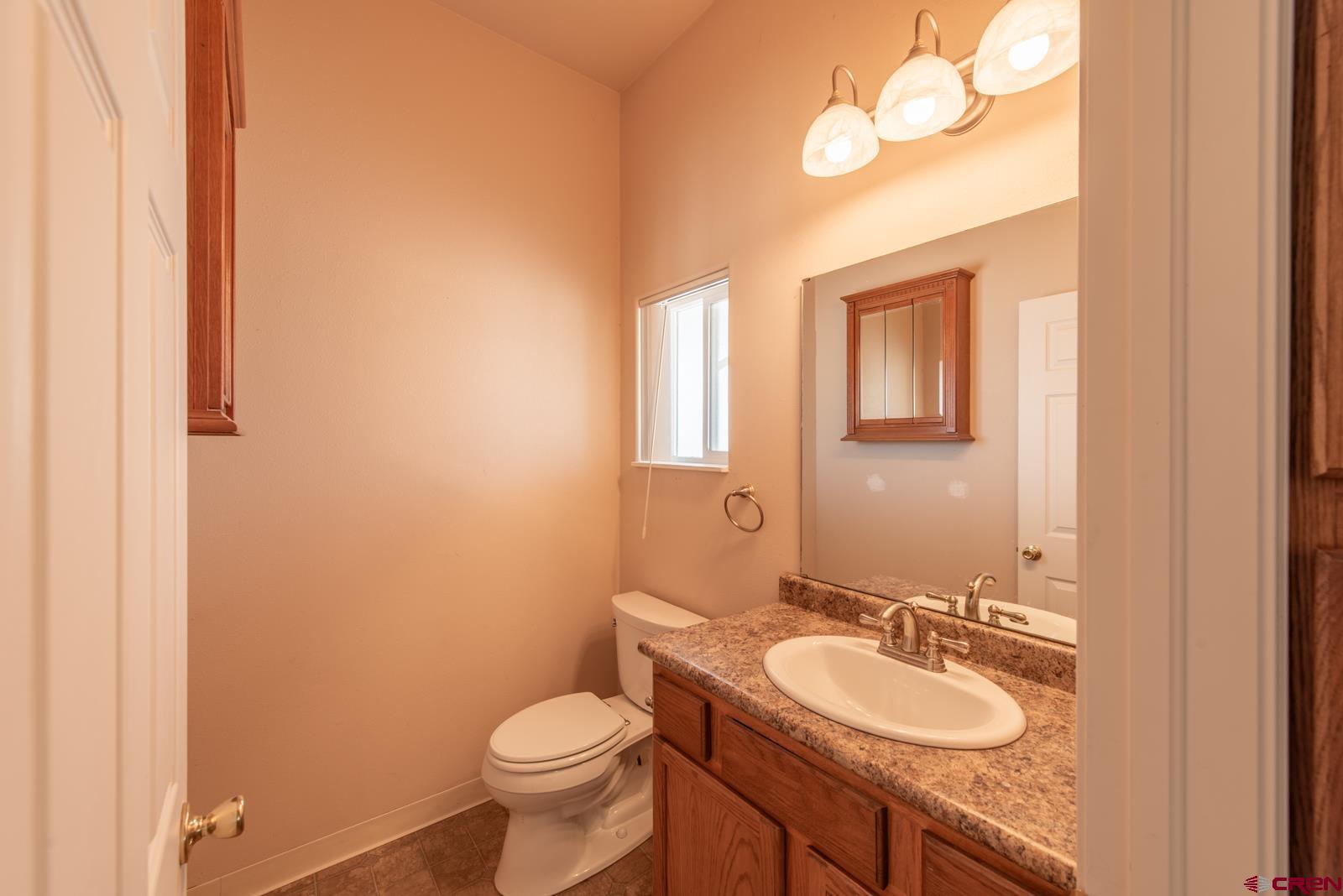 11604 5800th Road Montrose, CO 81403 - Photo 21 of 43 a bathroom with a granite countertop sink toilet and a mirror