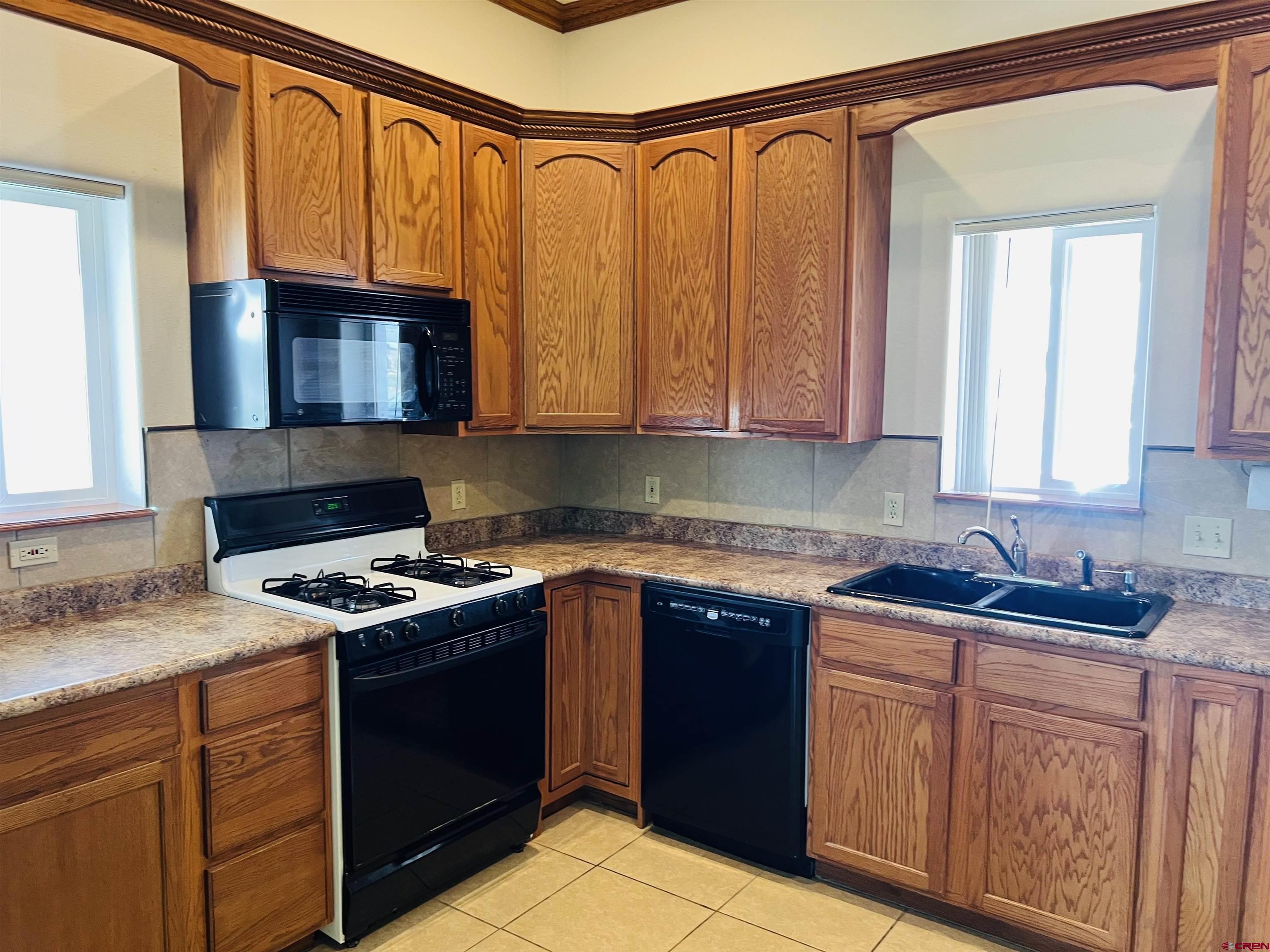 11604 5800th Road Montrose, CO 81403 - Photo 3 of 43 a kitchen with stainless steel appliances granite countertop a sink stove and cabinets