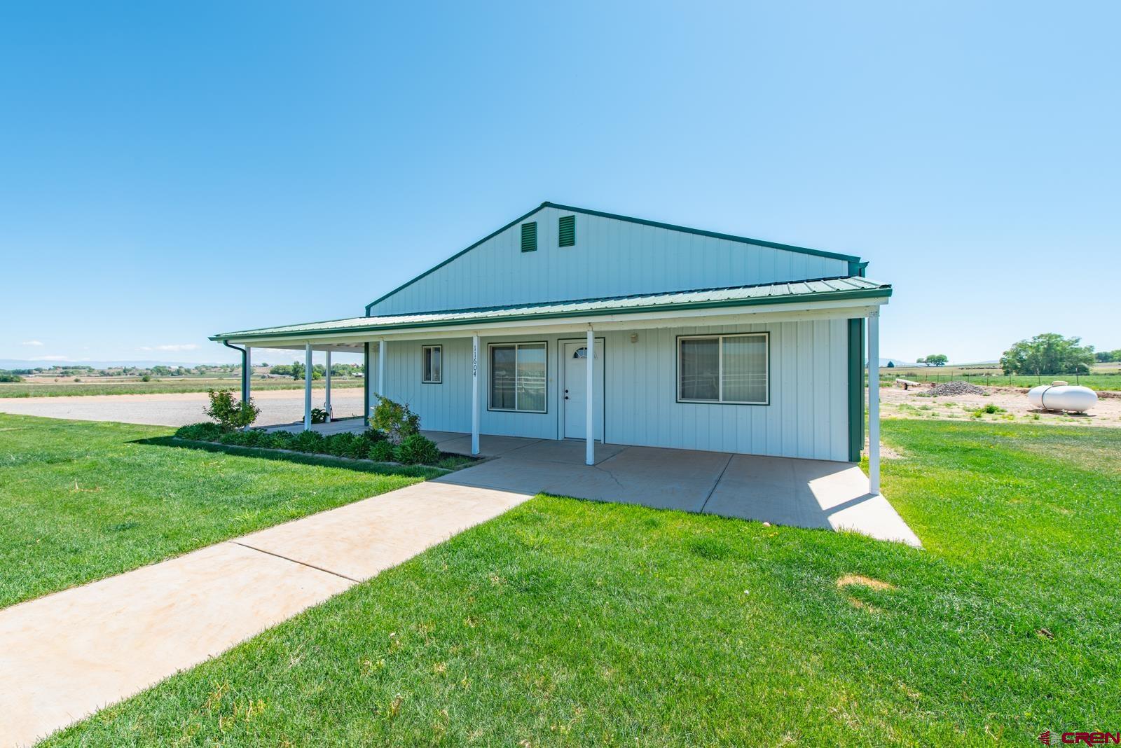 11604 5800th Road Montrose, CO 81403 - Photo 36 of 43 a front view of a house with a yard and garage