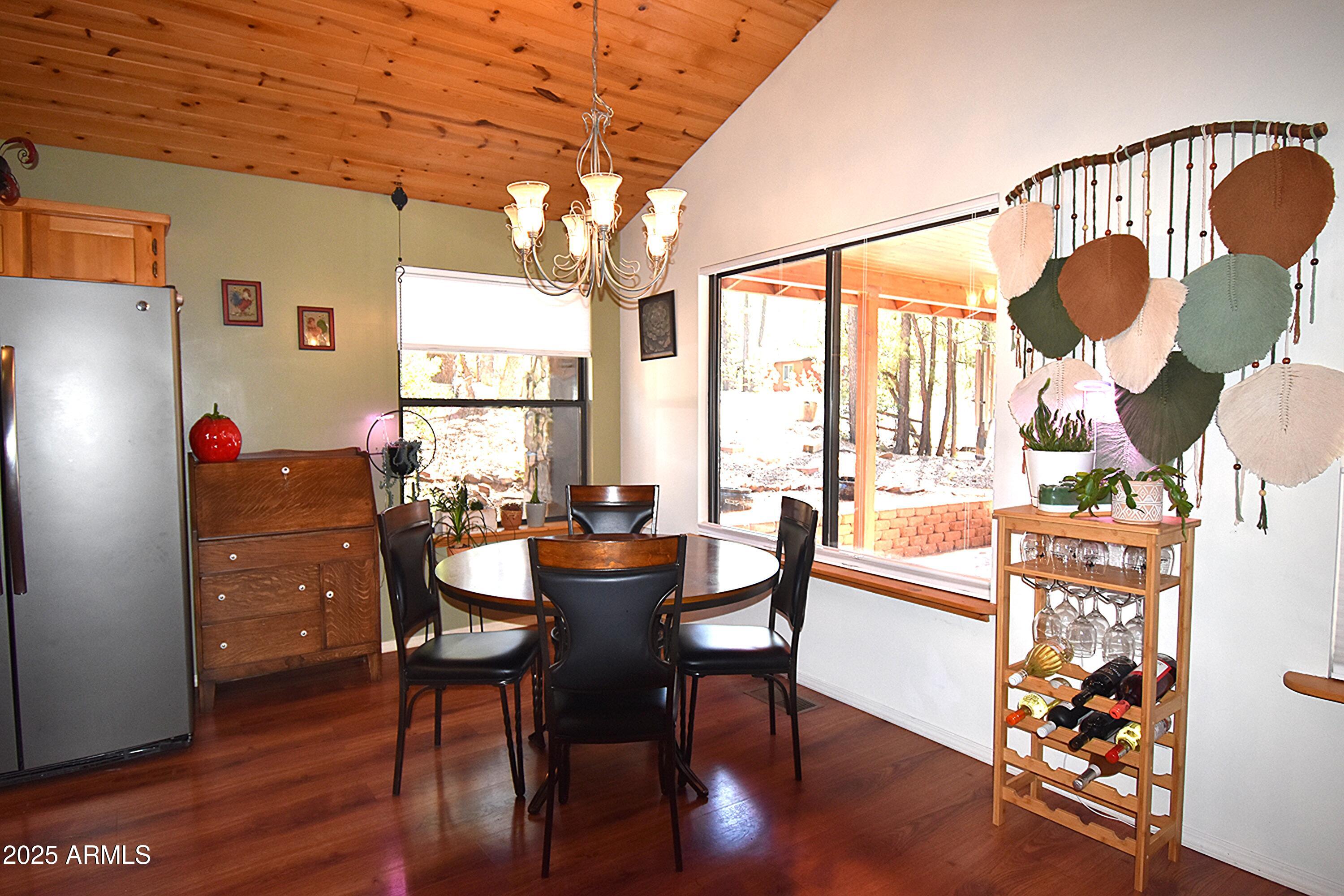 8742 Tonto Rim Drive Pine, AZ 85544 - Photo 12 of 41 a dining room with furniture a chandelier and wooden floor