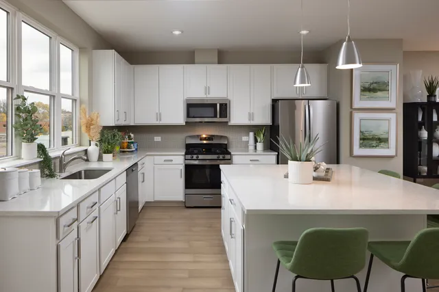 a kitchen with stainless steel appliances a stove a sink a refrigerator a center island and a window