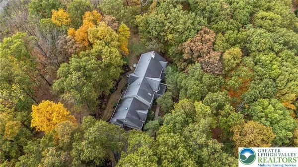 a view of a house with a yard and large trees