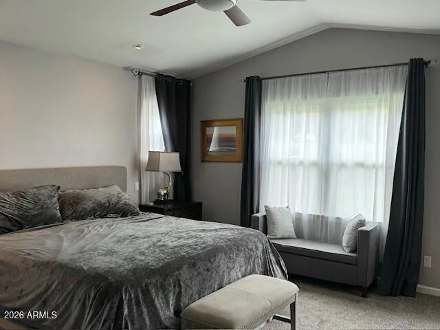 a bedroom with a bed couch and a large window
