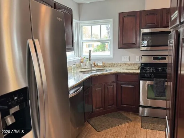 a kitchen with stainless steel appliances granite countertop a refrigerator a stove a sink and a microwave