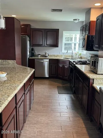 a kitchen with stainless steel appliances granite countertop a stove refrigerator and a microwave