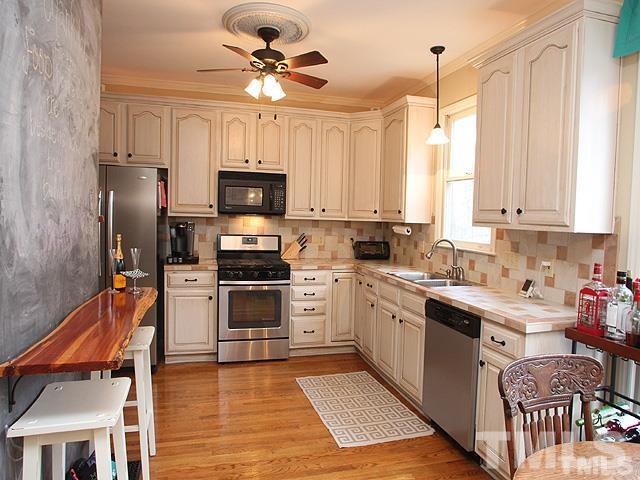 5944 Dunbarton Way Raleigh, NC 27613 - Photo 2 of 19 a kitchen with stainless steel appliances a stove sink microwave and cabinets
