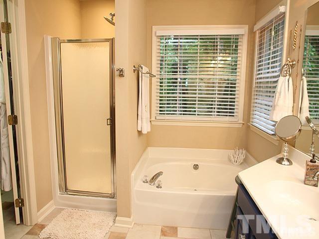 5944 Dunbarton Way Raleigh, NC 27613 - Photo 6 of 19 a bathroom with a tub a sink and a window