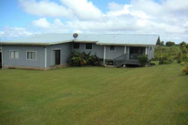 a front view of house with yard and trees