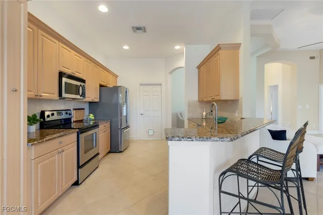 a kitchen with stainless steel appliances kitchen island granite countertop a sink and cabinets