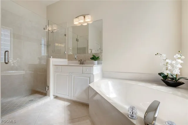 a bathroom with a tub a sink and a mirror