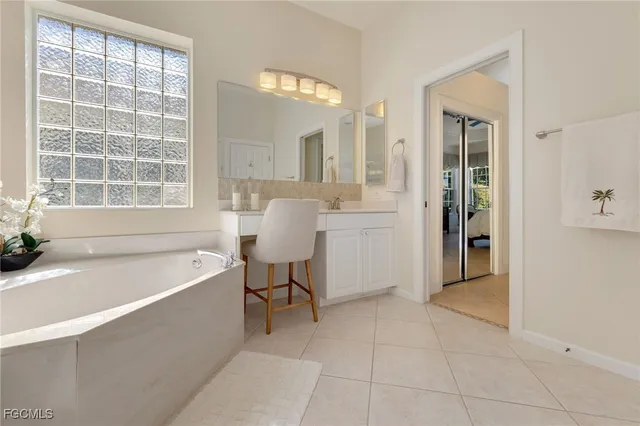 a spacious bathroom with a tub sink and mirror