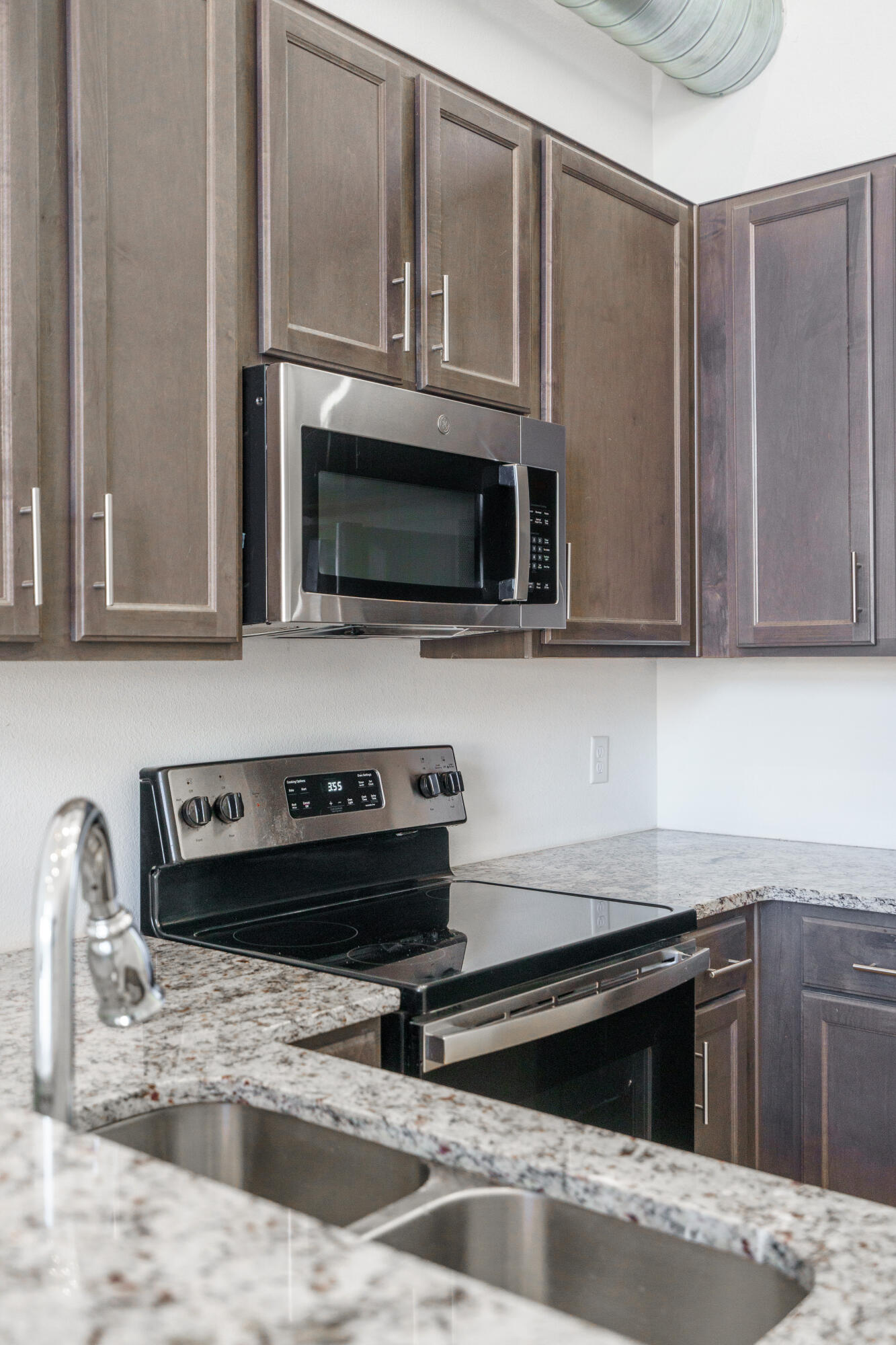 2007 Main Street, Unit 3 Lubbock, TX 79401 - Photo 17 of 23 a kitchen with granite countertop a stove and a microwave
