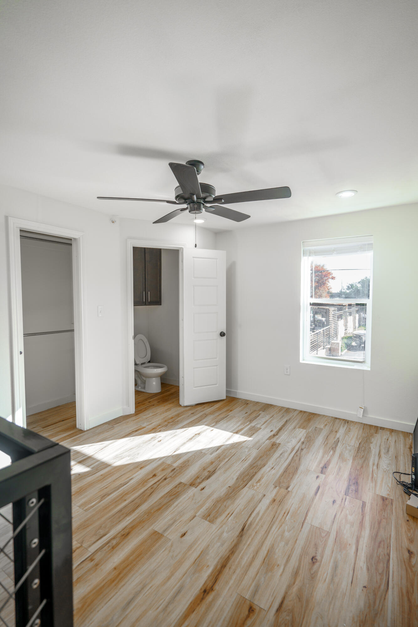 2007 Main Street, Unit 3 Lubbock, TX 79401 - Photo 19 of 23 an empty room with wooden floor a ceiling fan and windows