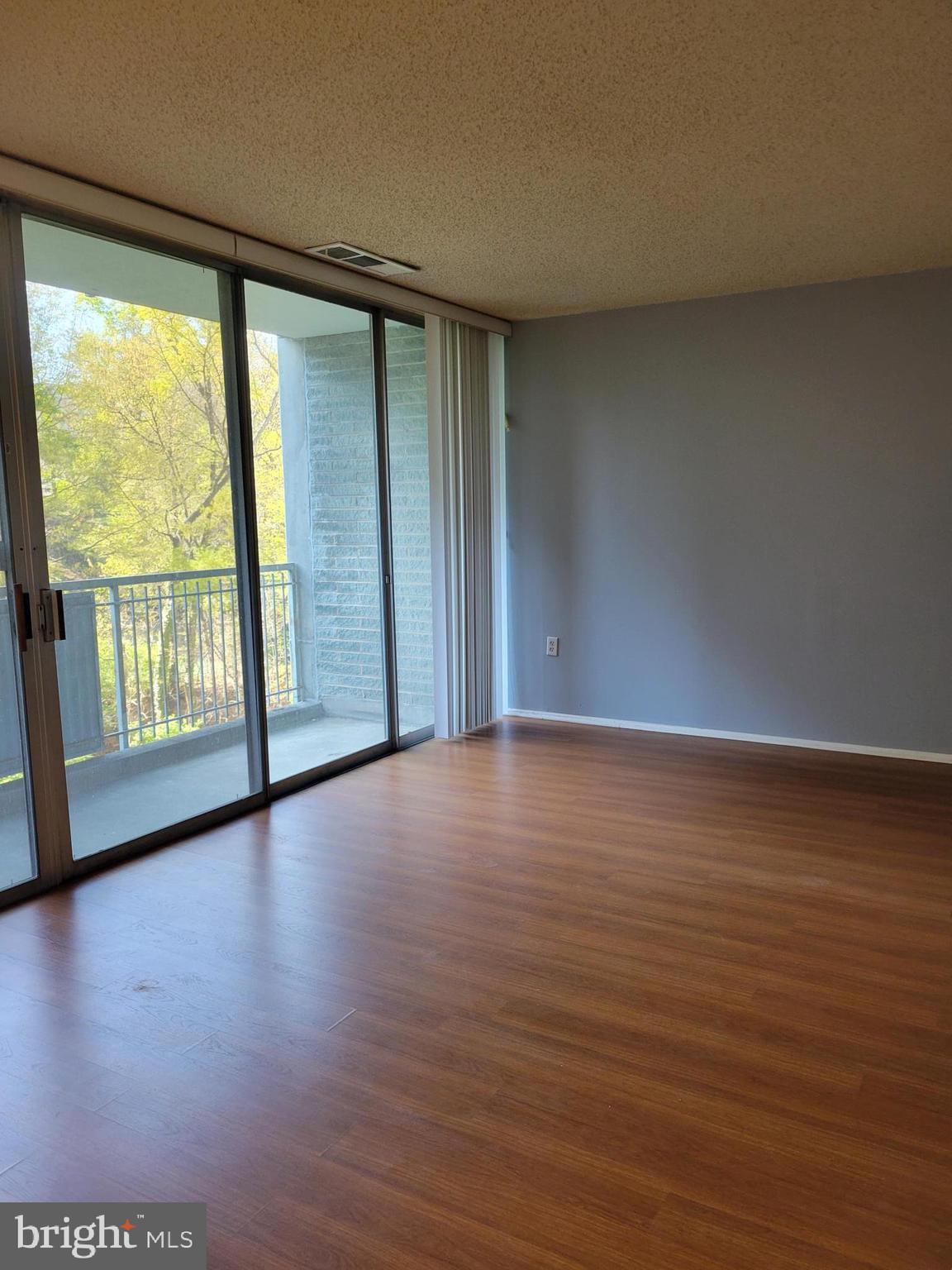 1830 Metzerott Road, Unit 103 Hyattsville, MD 20783 - Photo 4 of 41 a view of an empty room with wooden floor and a window