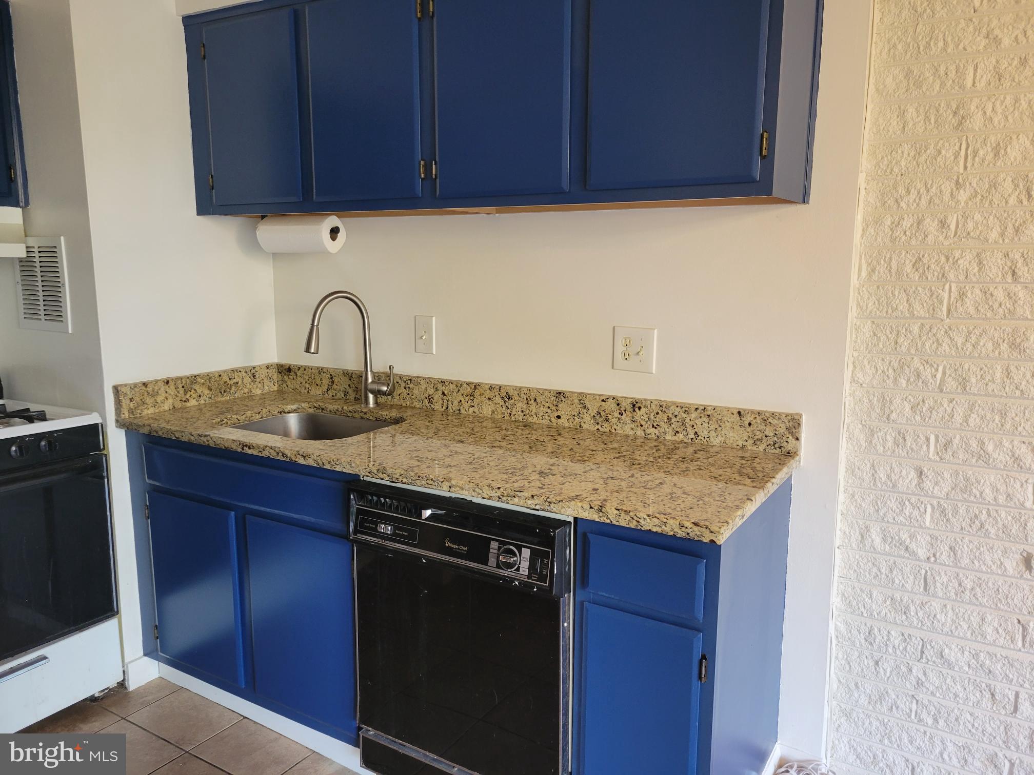 1830 Metzerott Road, Unit 103 Hyattsville, MD 20783 - Photo 9 of 41 a kitchen with granite countertop wood cabinets stainless steel appliances and a sink