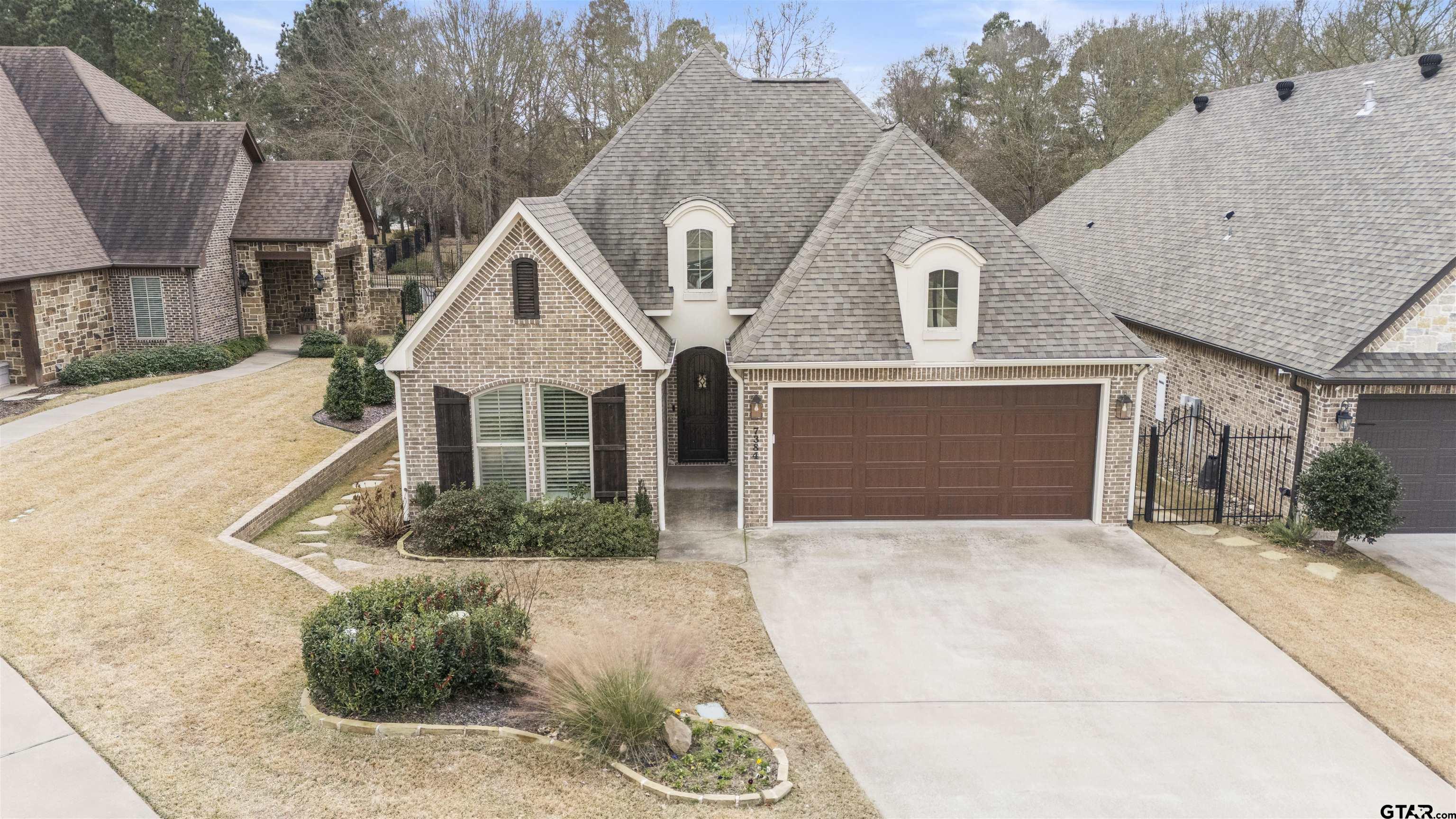 7384 Lake Pointe Cove Tyler, TX 75703 - Photo 2 of 18 a front view of a house with a yard and garage