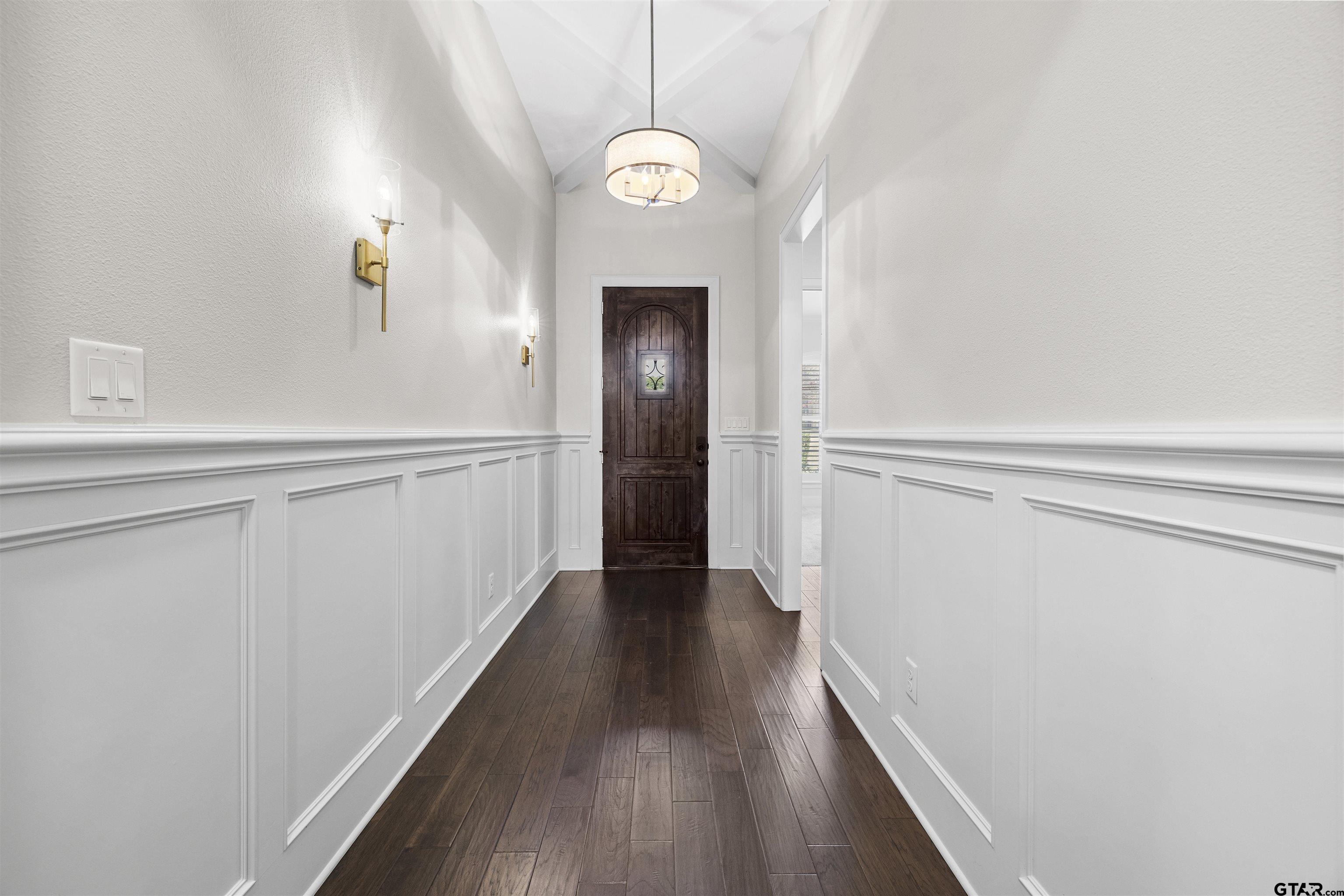 7384 Lake Pointe Cove Tyler, TX 75703 - Photo 3 of 18 a view of a hallway with wooden floor and a chandelier