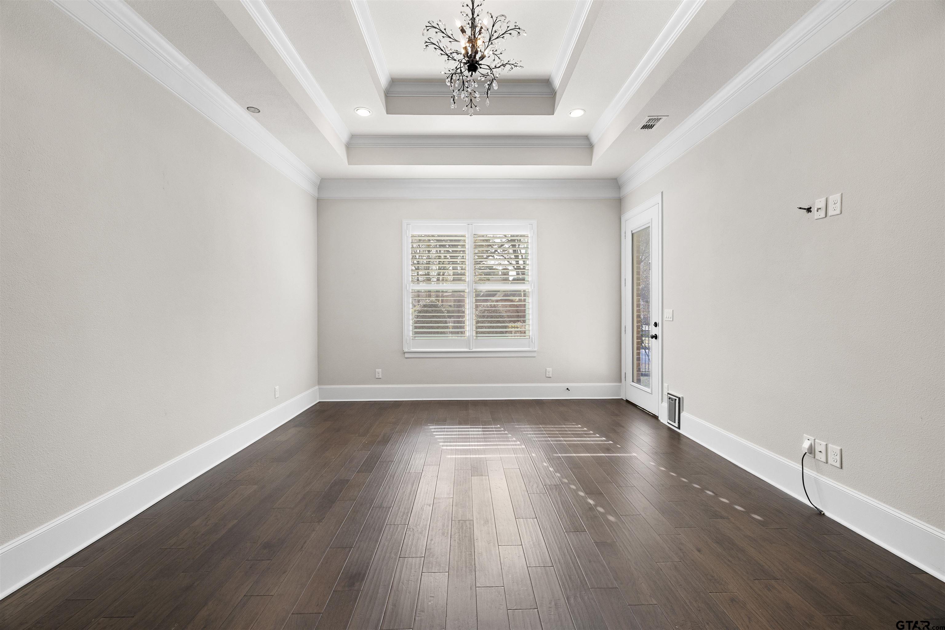 7384 Lake Pointe Cove Tyler, TX 75703 - Photo 7 of 18 a view of an empty room with wooden floor and a window