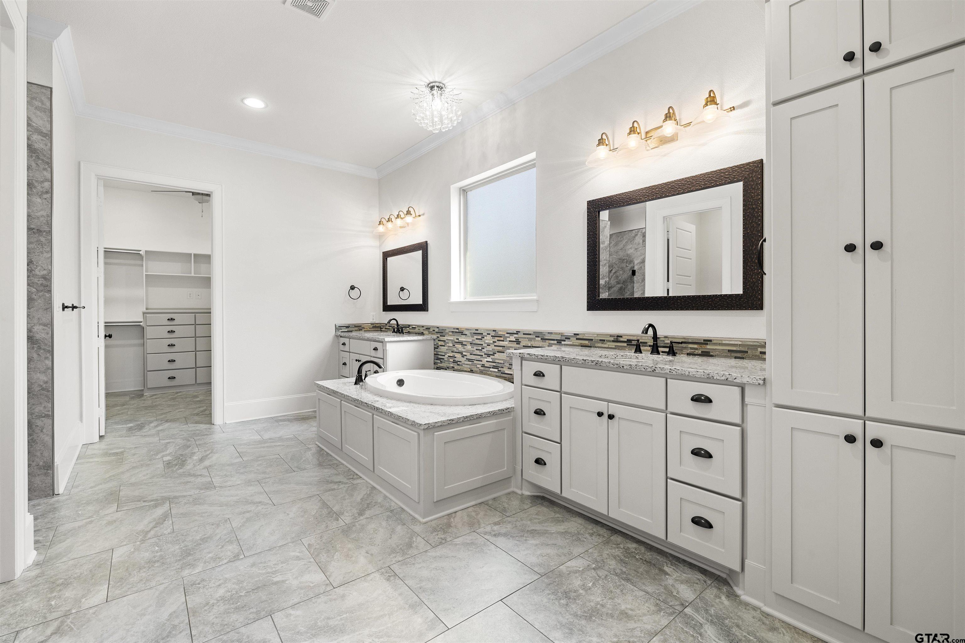 7384 Lake Pointe Cove Tyler, TX 75703 - Photo 8 of 18 a spacious bathroom with a double vanity sink a mirror and a bathtub