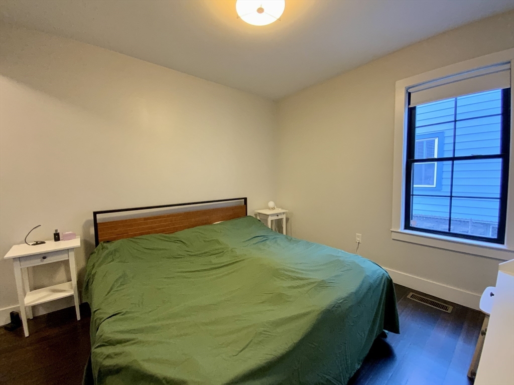 65 Broadway, Unit 1 Arlington, MA 02474 - Photo 13 of 15 a bedroom with a bed and a window