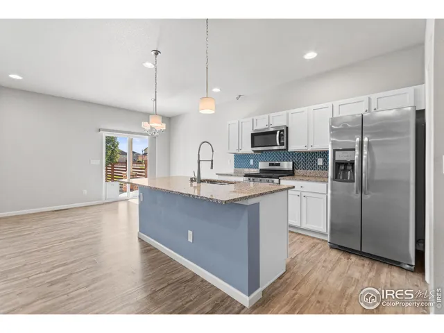 a kitchen with kitchen island a counter top space stainless steel appliances and a window