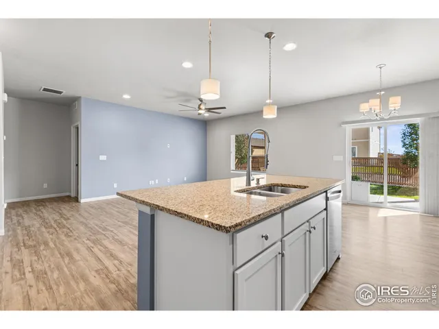 a kitchen with a sink a counter space and wooden floor