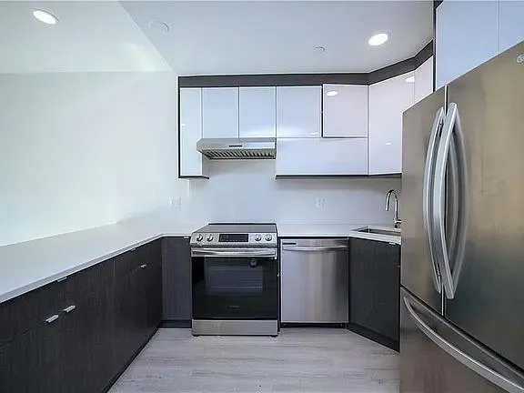 a kitchen with stainless steel appliances granite countertop a refrigerator and a sink