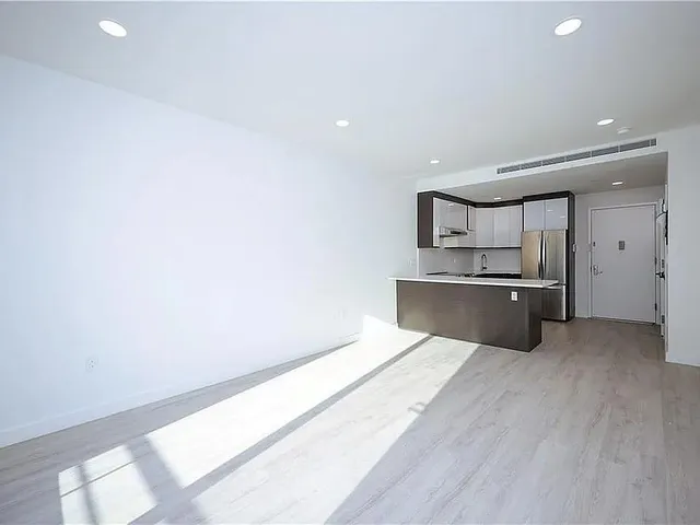 a view of a kitchen with a sink and a refrigerator